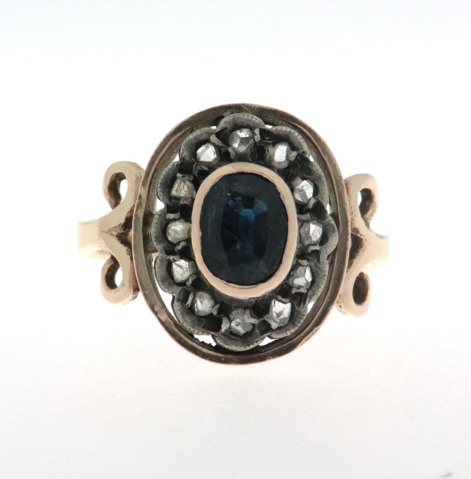Anello in oro 18 kt e argento in stile antico con zaffiro ovale al centro contornato da diamanti