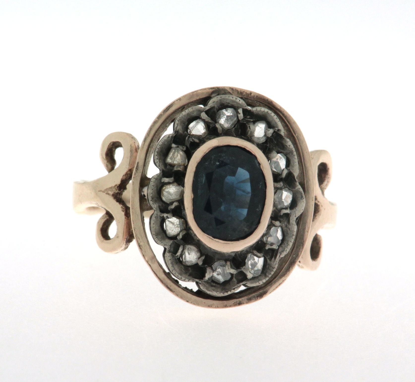 Anello in oro 18 kt e argento in stile antico con zaffiro ovale al centro contornato da diamanti