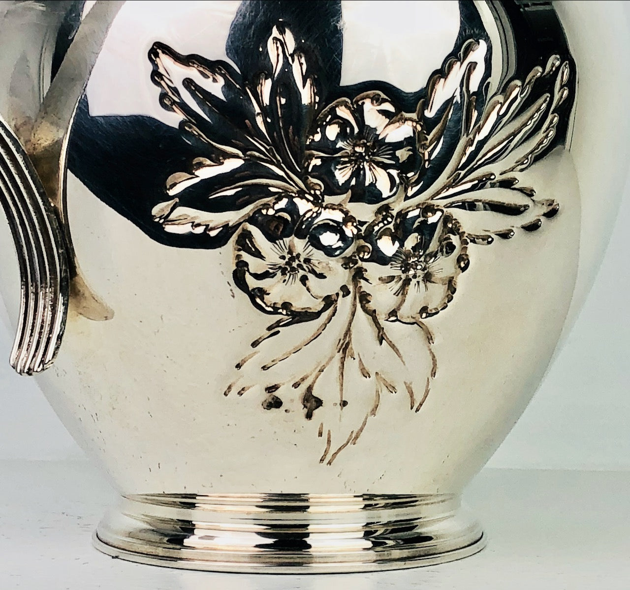 Brocca in argento 800 d'epoca con manico lavorata e disegno floreale a sbalzo