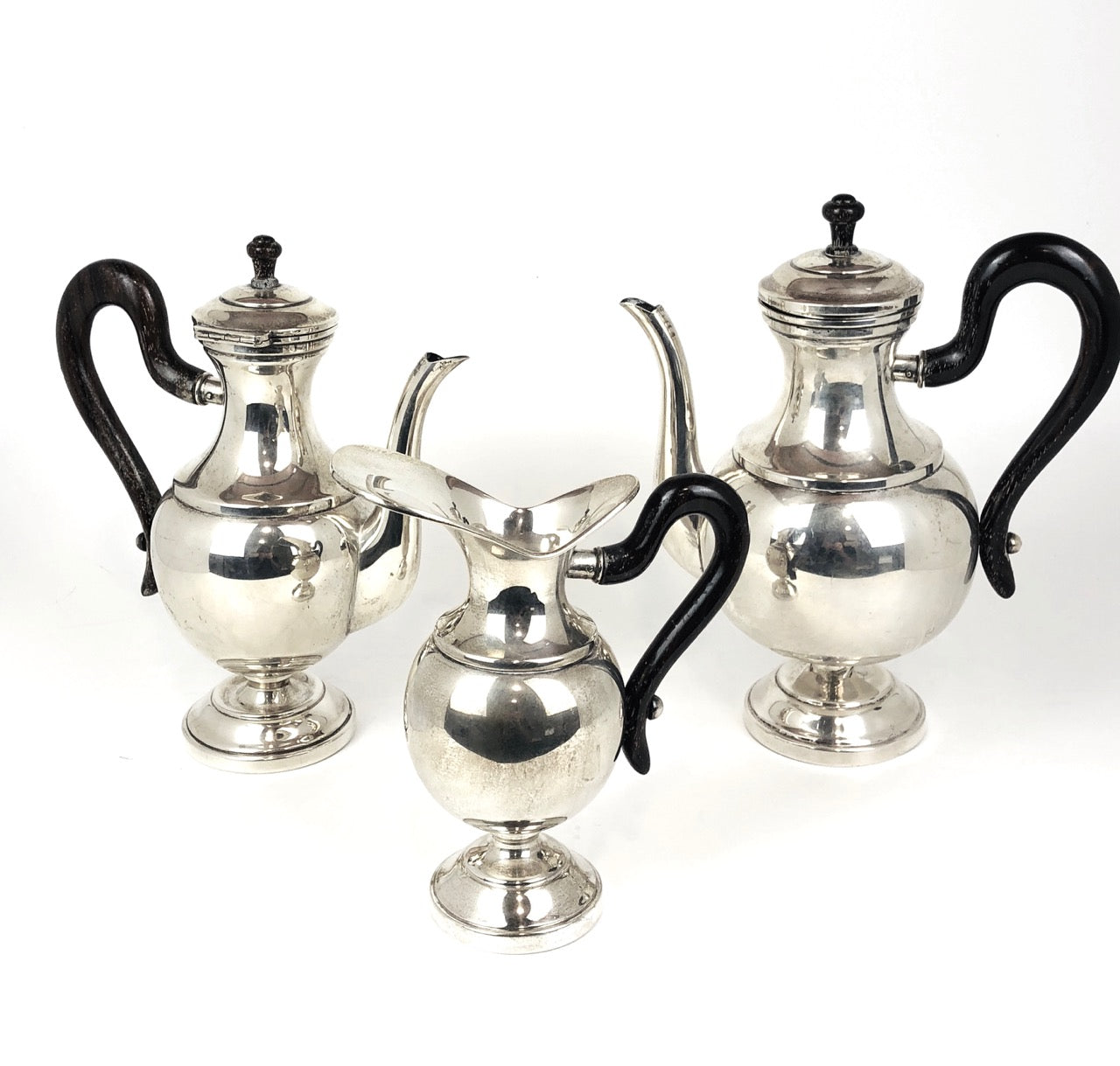 Tre pezzi in argento, teiera, caffettiera, lattiera, con manici in legno color nero.